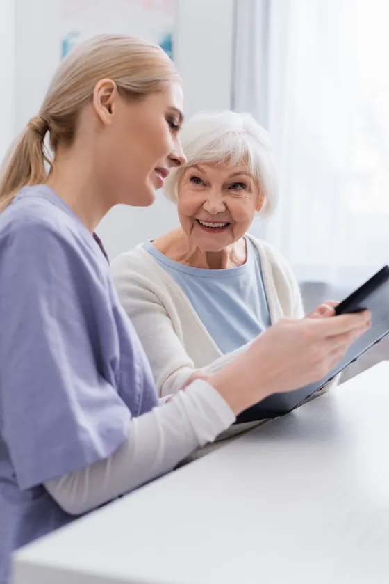 Pflegekraft im Gespräch mit einer Seniorin